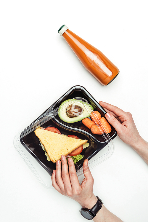 cropped image of woman opening plastic lunch box with food isolated on white