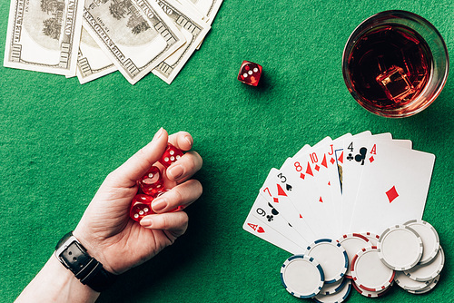 Woman holding dice by casino table with money and chips