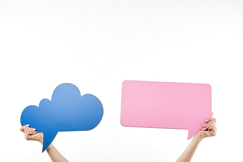 cropped view of woman with blue thought and pink speech bubbles in hands isolated on white