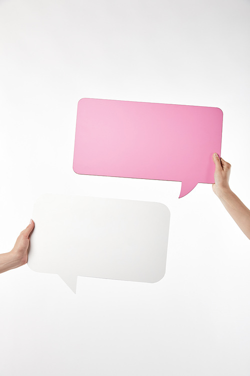 cropped view of two women with speech bubbles in hands isolated on white