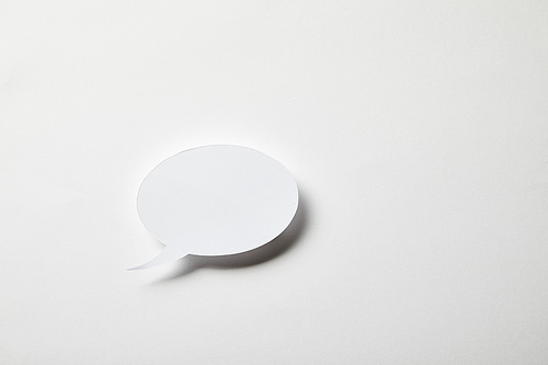 small paper speech bubble on white surface