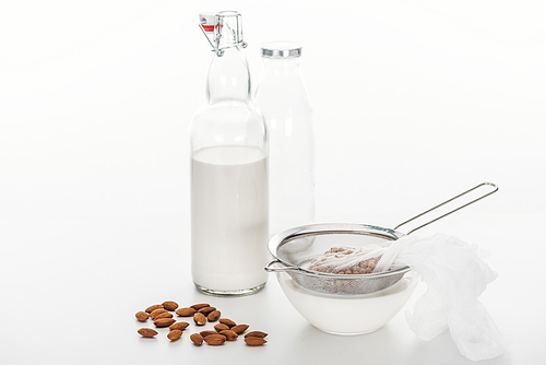 fresh almond and chickpea vegan milk in bowl and bottle near ingredients