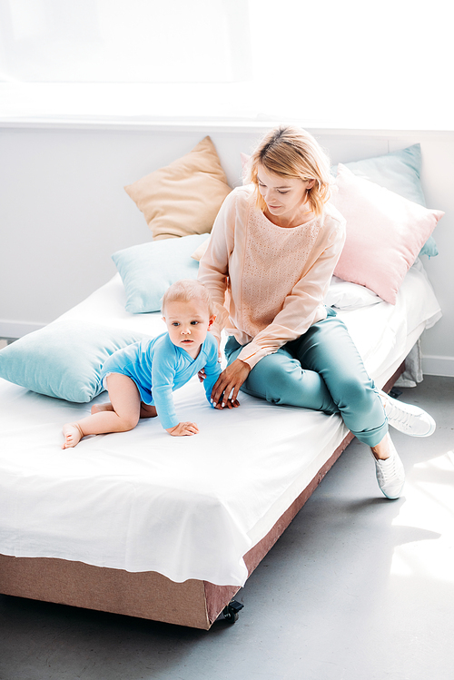 high angle view of mother and child spending time together on bed at home