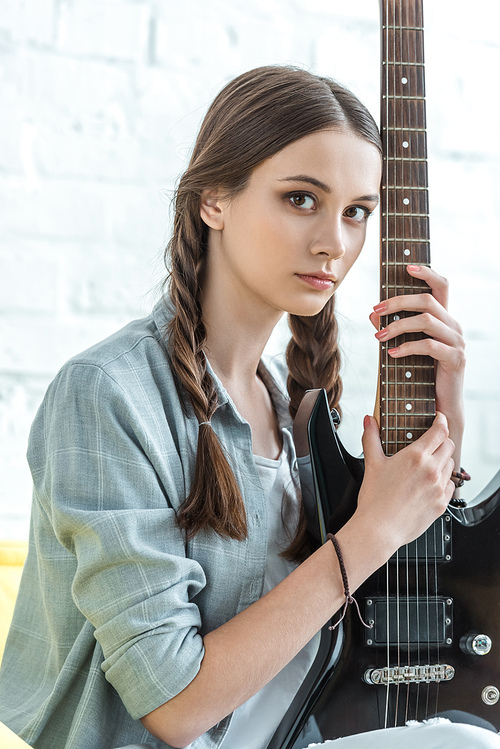 beautiful teen girl posing with electric guitar
