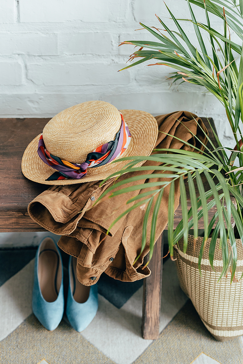 straw hat and jacket on wooden bench in corridor