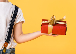 cropped shot of kid holding wrapped gift isolated on yellow