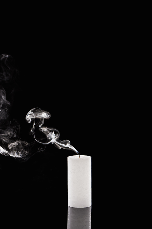extinct white candle with smoke on black background