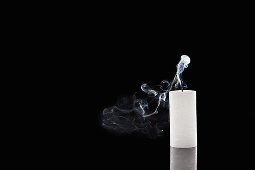 extinct white candle with smoke on black background