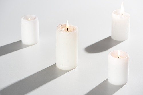 burning candles glowing on white background with shadow