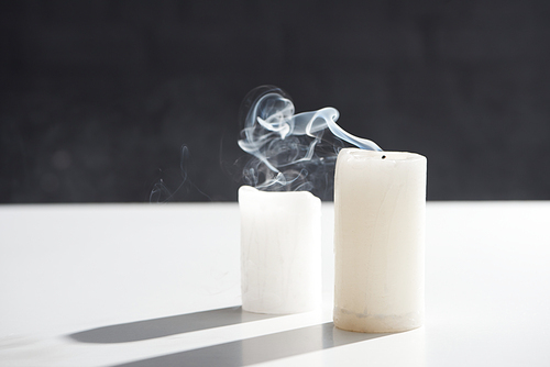 extinct white candles with smoke on black background