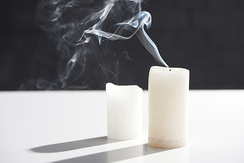 extinct white candles with smoke on black background