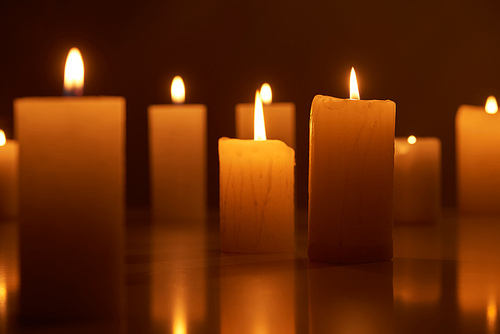 selective focus of burning candles glowing in dark