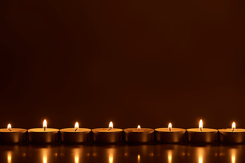 burning white candles glowing in dark