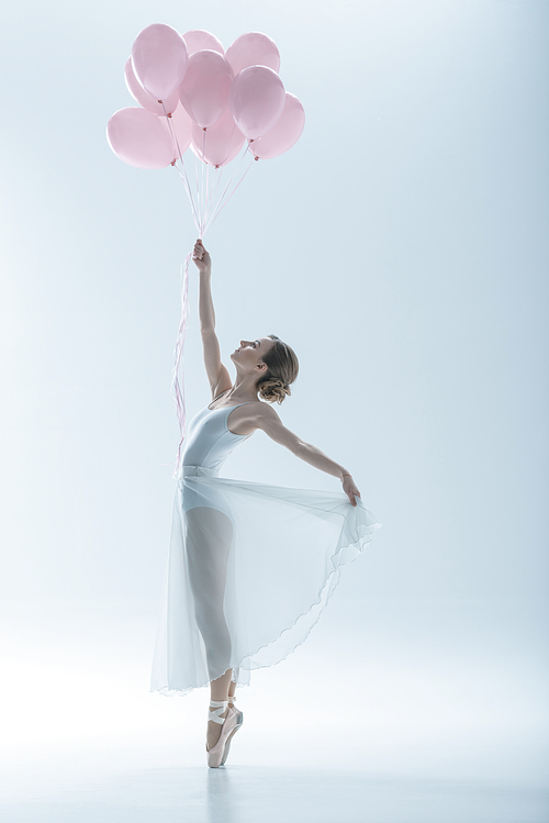 elegant ballet dancer in white dress with pink balloons, isolated on white