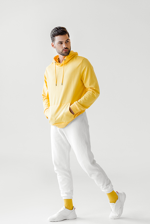 handsome young man in yellow hoodie posing on white