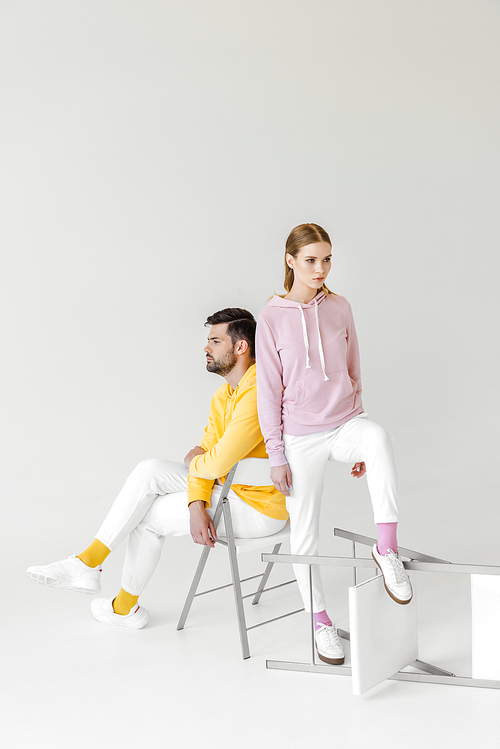 young male and female models in stylish hoodies on white