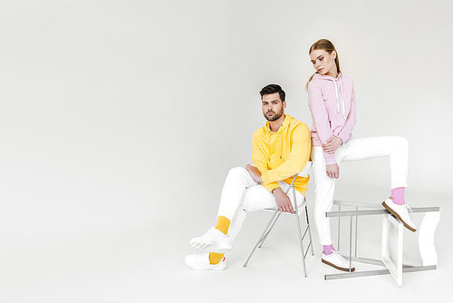 attractive young male and female models in colorful hoodies on white