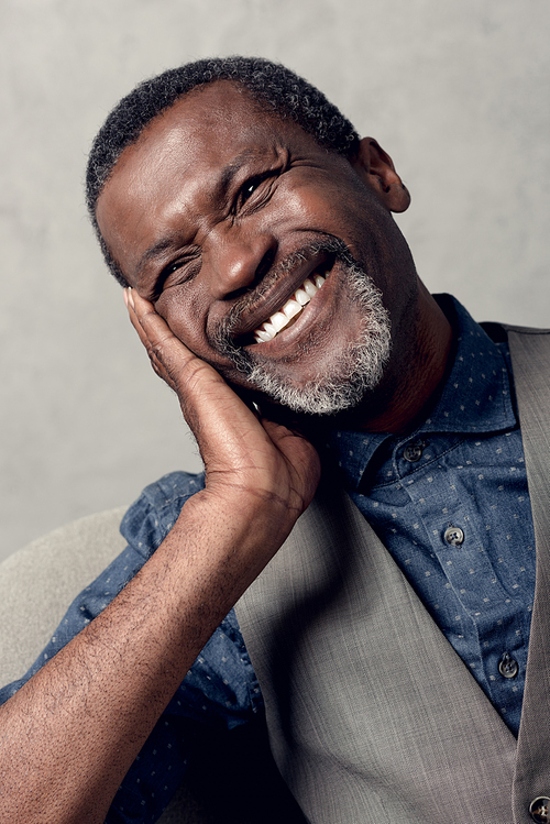 portrait of laughing mature african american man in waistcoat