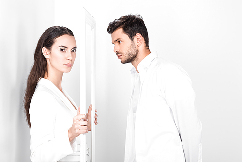 beautiful adult woman holding frame while handsome man looking on white background