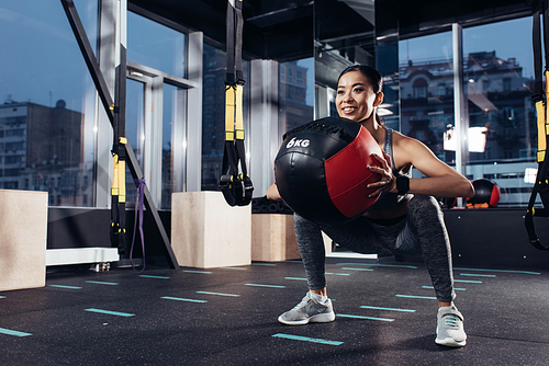 attractive asian girl exercising with medicine ball at gym
