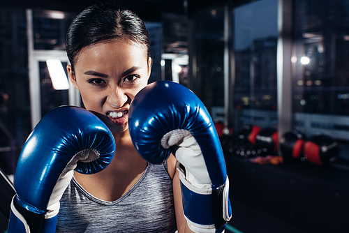 close up view of shouting girl in boxing gloves at gym