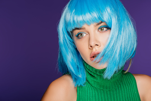 pretty girl posing in blue wig, isolated on purple