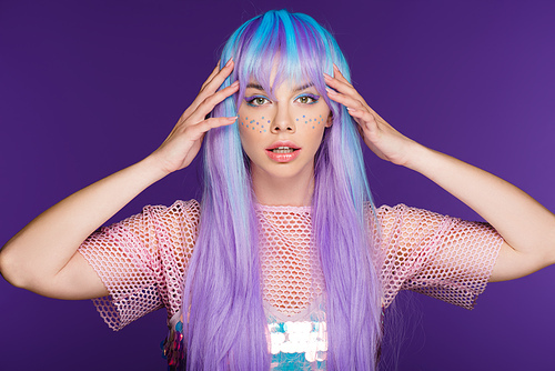 pretty girl posing in violet wig with stars on face, isolated on purple