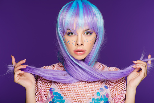 beautiful young woman posing in violet wig with stars on face, isolated on purple
