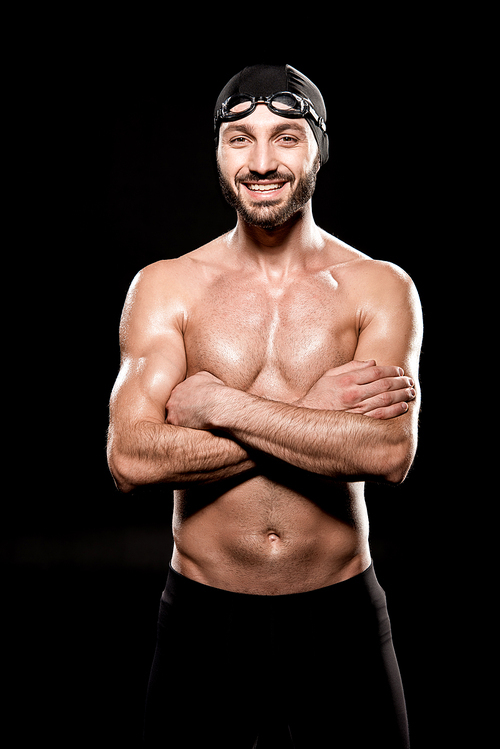 cheerful swimmer standing with crossed arms isolated on black