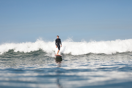 active man surfing wave in ocean