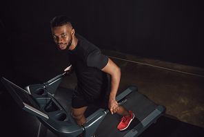 high angle view of young african american sportsman training on treadmill and 