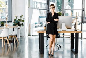 beautiful businesswoman standing with crossed arms and  in office