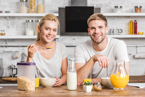 smiling couple  and having breakfast in kitchen