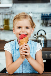 beautiful happy child eating delicious ice cream and smiling at camera