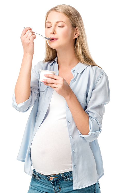 attractive pregnant woman with closed eyes eating yogurt isolated on white