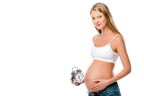 blonde pregnant woman holding alarm clock isolated on white