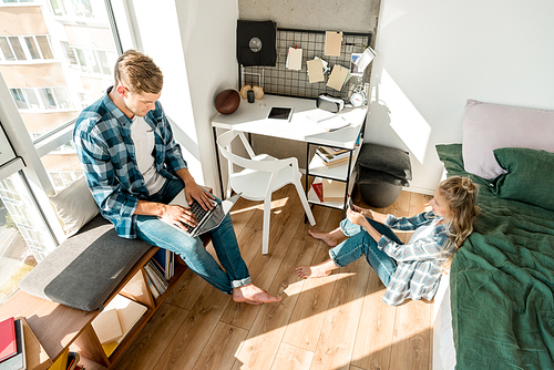 high angle view of couple using digital devices at home