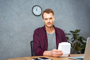 selective focus of businessman having lunch with burger at table in modern office