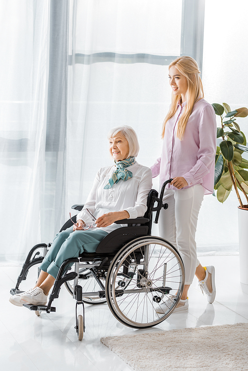 young woman pushing . with senior woman in nursing home
