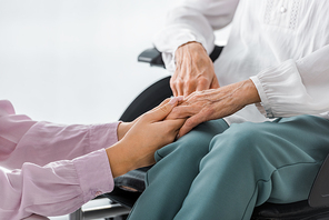 young and senior women holding hands in nursing home