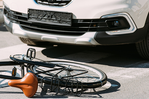 close up view of broken bicycle and car on road, car accident concept