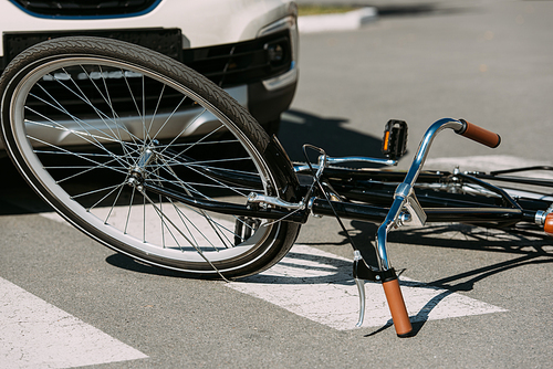 close up view of broken bicycle and car on road, car accident concept