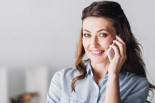close-up portrait of smiling adult woman talking by phone and 