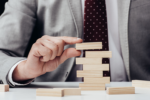 cropped view of man with wooden blocks symbolizing building success