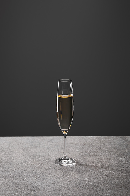 one glass of sparkling wine for celebrating christmas on grey