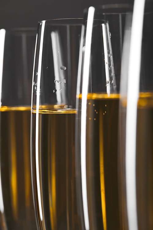 close up of champagne in glasses for celebrating christmas, isolated on grey