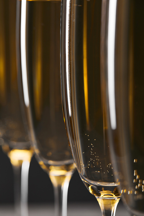 close up of sparkling wine in glasses for celebrating christmas eve on grey