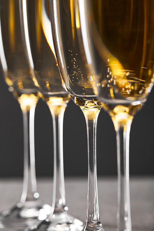 close up of sparkling wine in glasses on grey