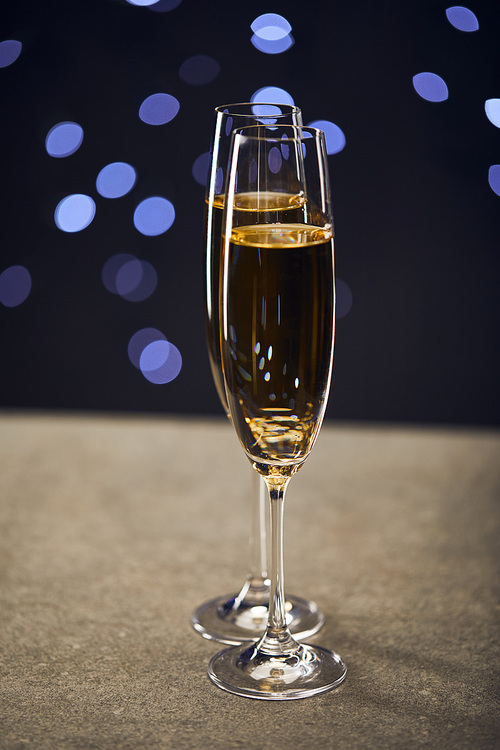 Sparkling wine in two glasses with blue christmas lights bokeh