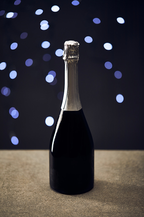 bottle of sparkling wine with blurred christmas lights